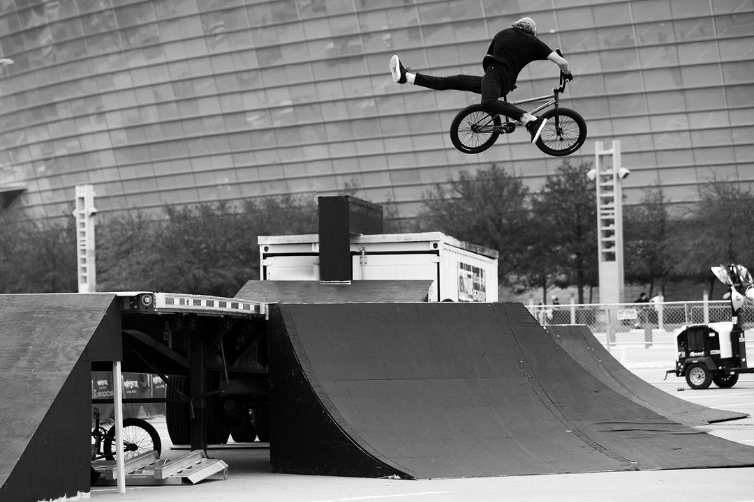 freestyle bmx shot of pro rider parker heath mid air twisting the bike and crossing his legs